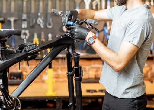 Man removing steering wheel from the bicycle at the workshop